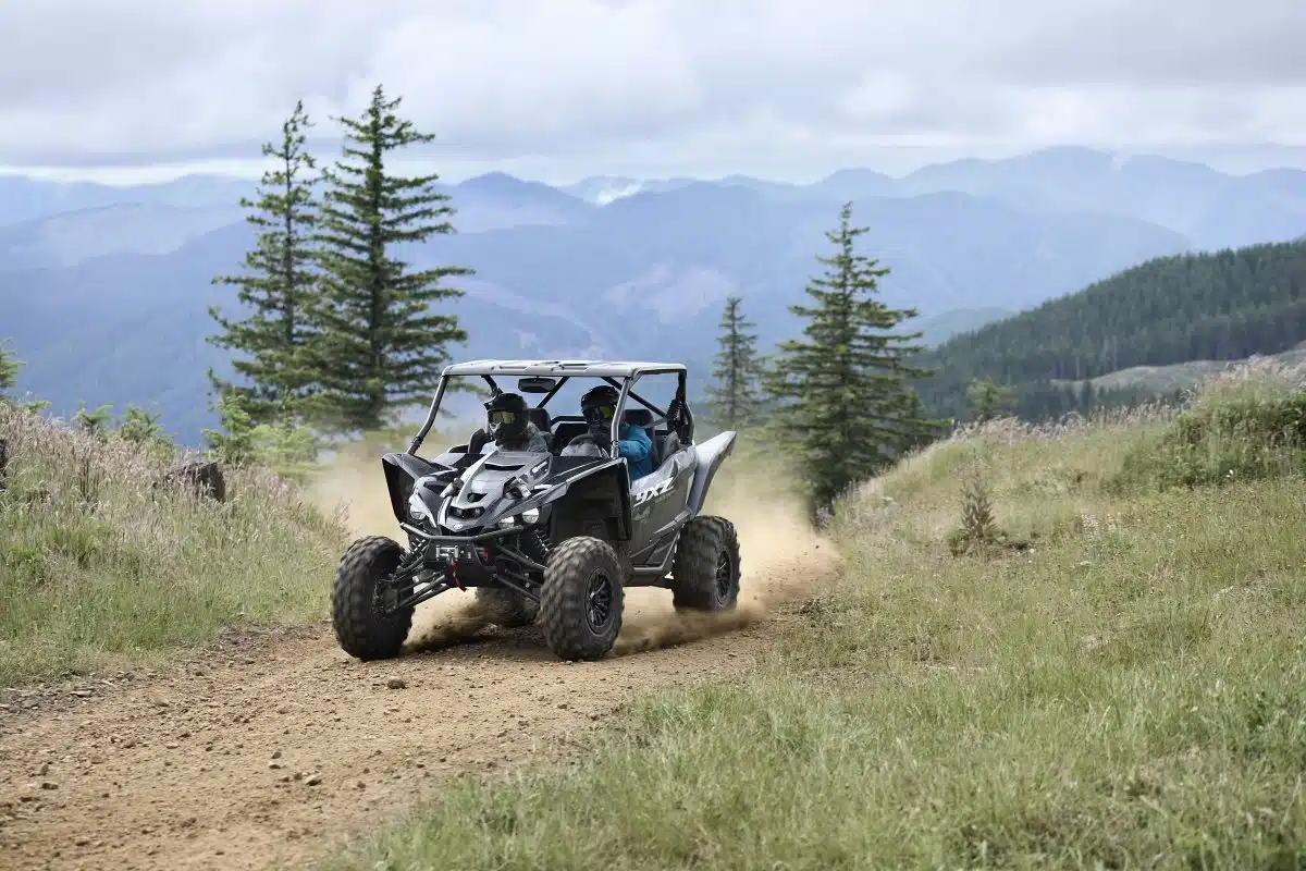 Side-by-side UTV kicking up dust on a trail